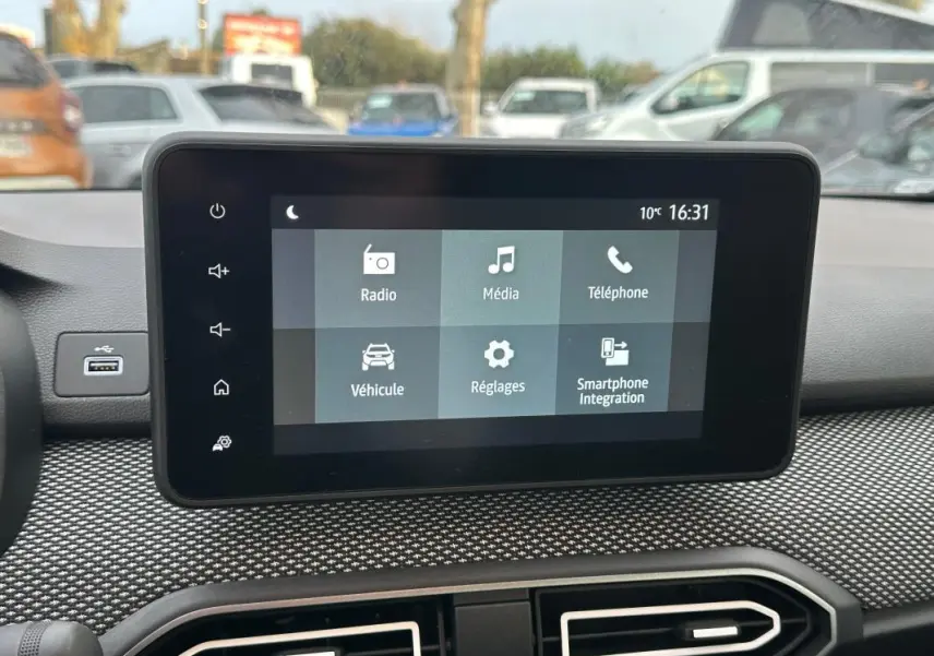 Écran tactile central du tableau de bord de la Dacia Sandero blanc, affichant les options multimédia et véhicule.