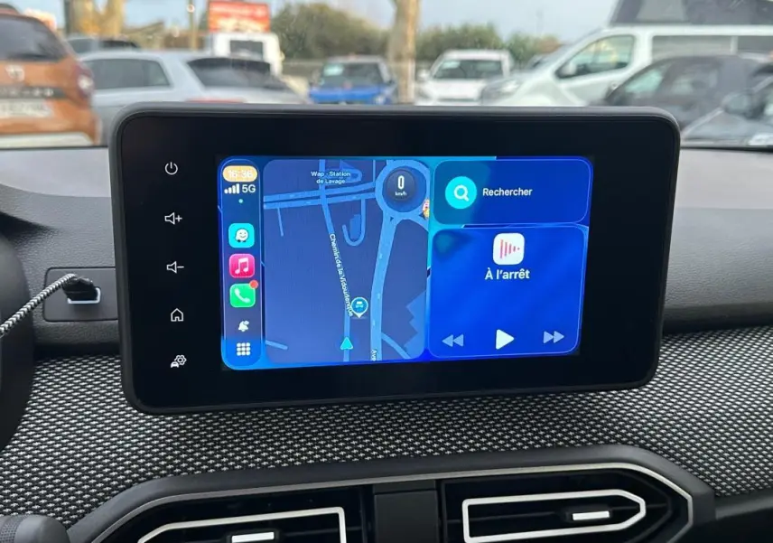 Écran tactile central du tableau de bord de la Dacia Sandero blanche, affichant un GPS en mode pause.
