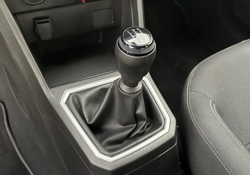 Gros plan sur le levier de vitesses manuel noir de la Dacia Sandero TCe 90 Expression 2024, intérieur gris.