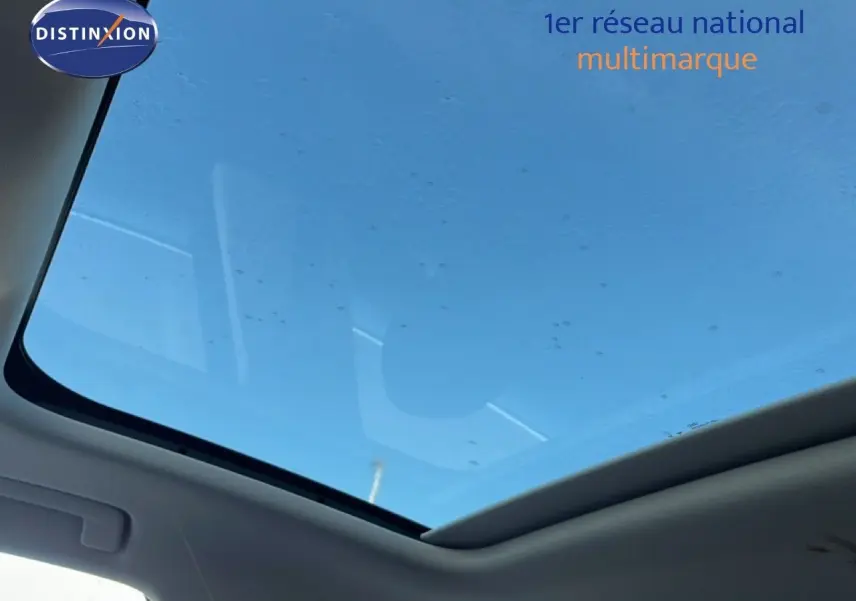 Toit panoramique ouvrant du SUV Audi Q3 Sportback 35 2.0 TDI noir mythic vu de l'intérieur vers le ciel bleu.