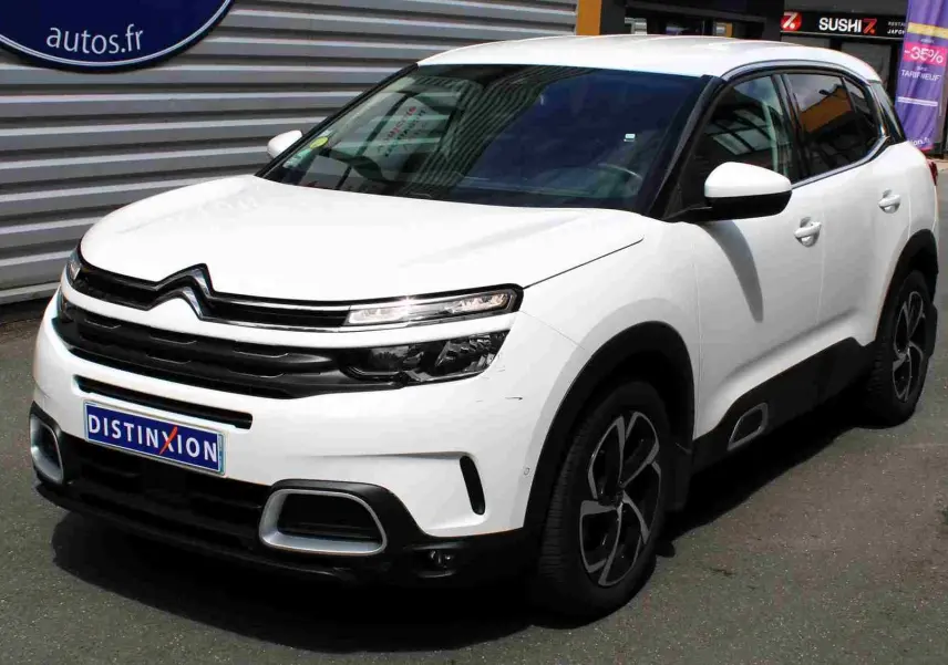 Vue 3/4 avant droit d'un Citroën C5 Aircross blanc avec jantes noires et détails de calandre noire.