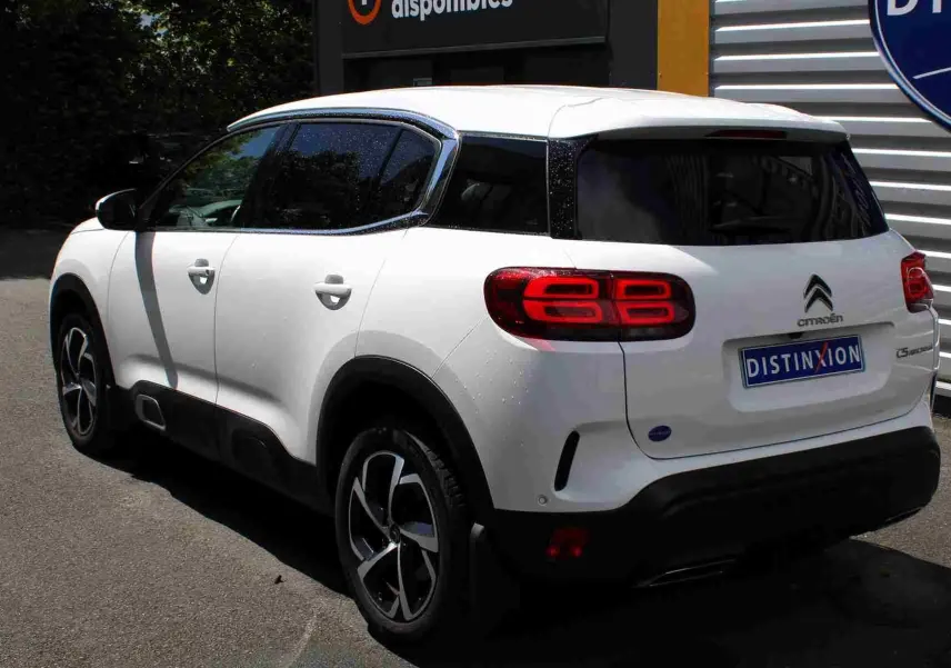 Vue 3/4 arrière droite du Citroën C5 Aircross blanc 2020 avec attelage et feux arrière LED distinctifs.
