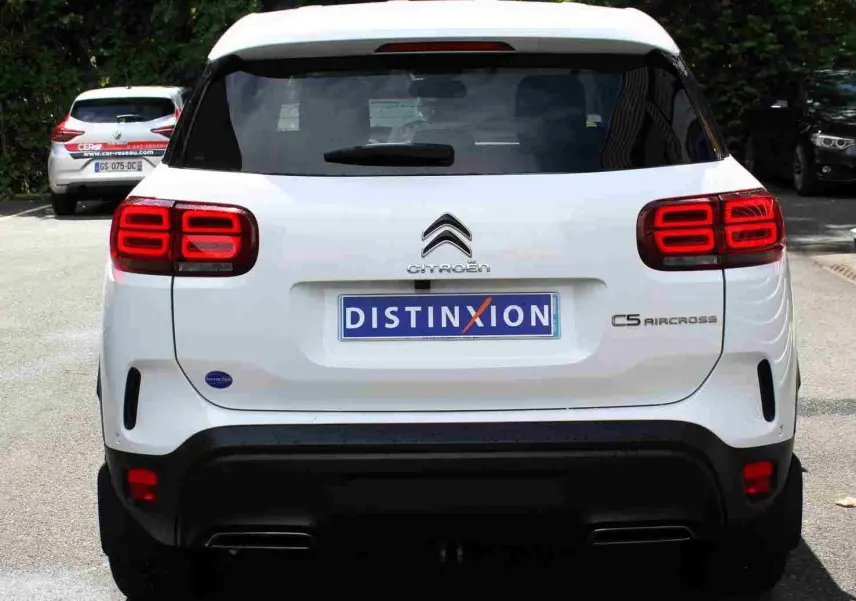 Vue arrière d'un Citroën C5 Aircross blanc avec feux arrière LED et attelage visible en stationnement.