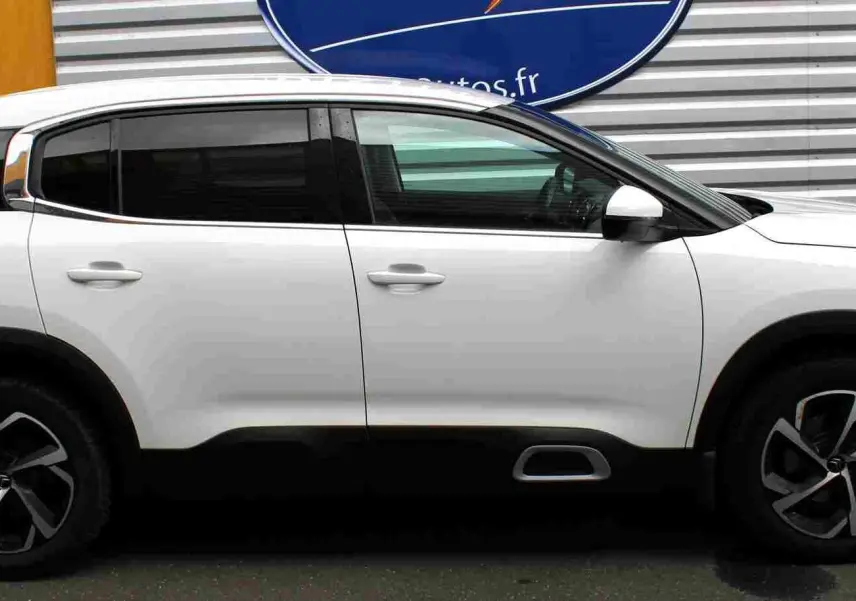Vue de profil côté gauche d'un Citroën C5 Aircross blanc de 2020 avec jantes noires et grises, et attelage visible.