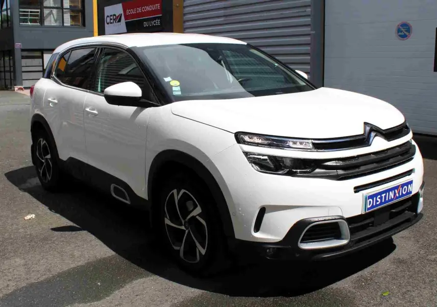 Citroën C5 Aircross blanc en 3/4 avant droit, avec jantes noires et détails chromés sur pare-chocs et calandre.