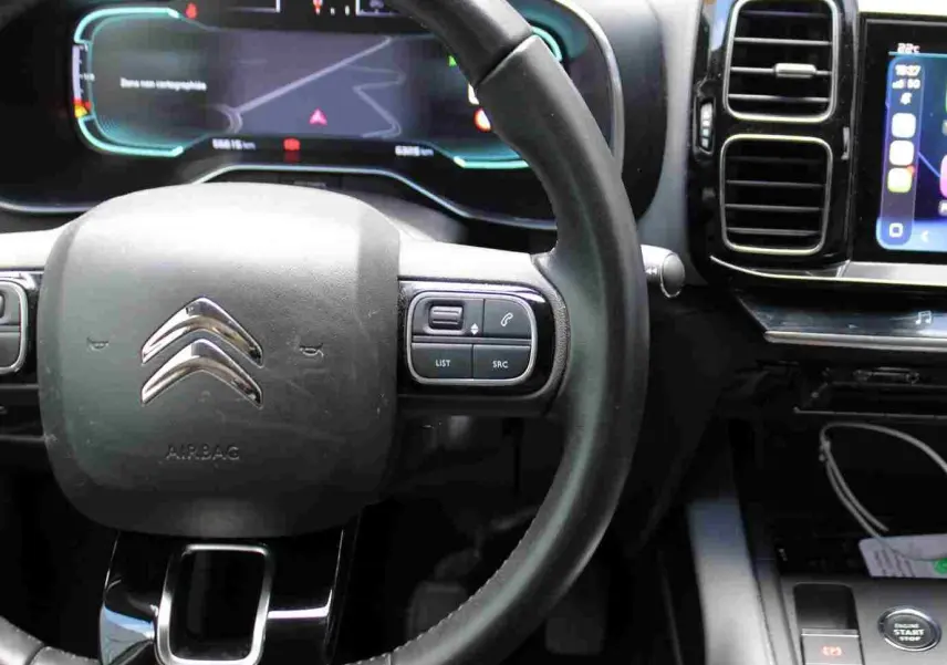 Vue rapprochée du volant noir et du tableau de bord numérique du Citroën C5 Aircross Shine 2020, avec écran tactile latéral.