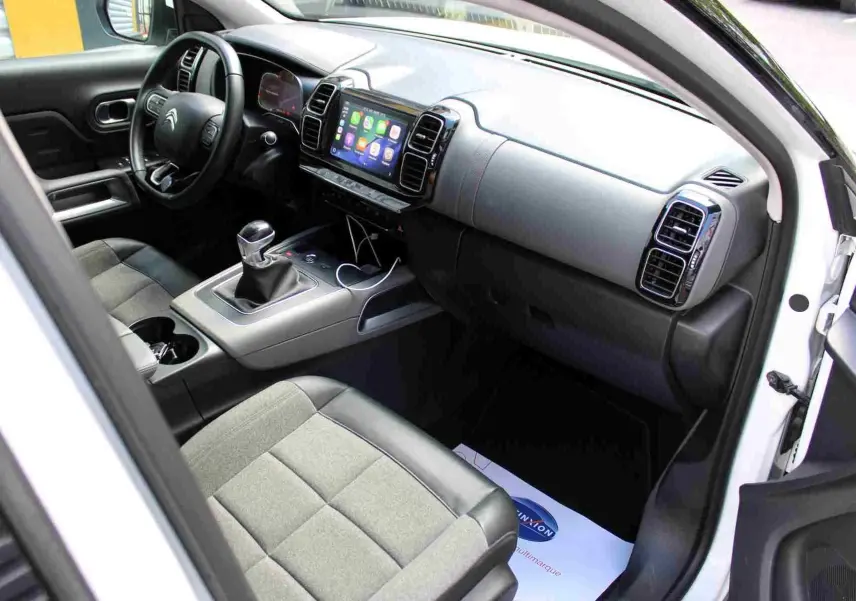 Vue intérieure côté conducteur du Citroën C5 Aircross blanc 2020, tableau de bord moderne avec écran tactile et sièges bicolores.