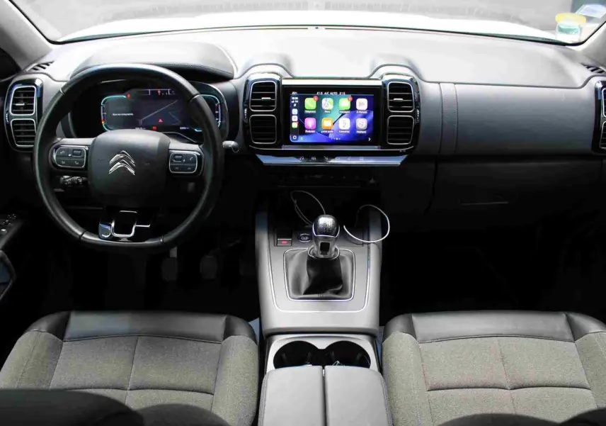 Vue intérieure avant du Citroën C5 Aircross Shine 2020, tableau de bord noir avec écran tactile et levier de vitesses manuel.