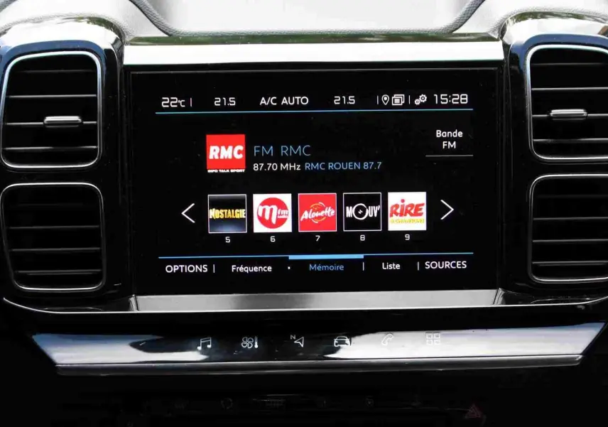 Écran tactile central du tableau de bord du Citroën C5 Aircross Shine blanc, affichant la radio FM avec plusieurs stations.