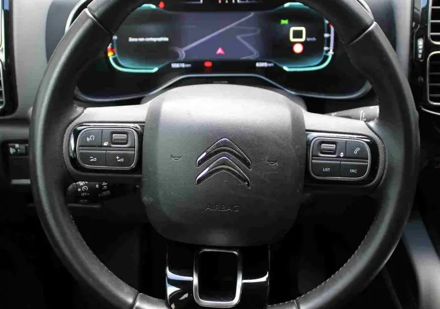 Vue rapprochée du volant noir du Citroën C5 Aircross 2020 avec commandes intégrées et tableau de bord numérique.