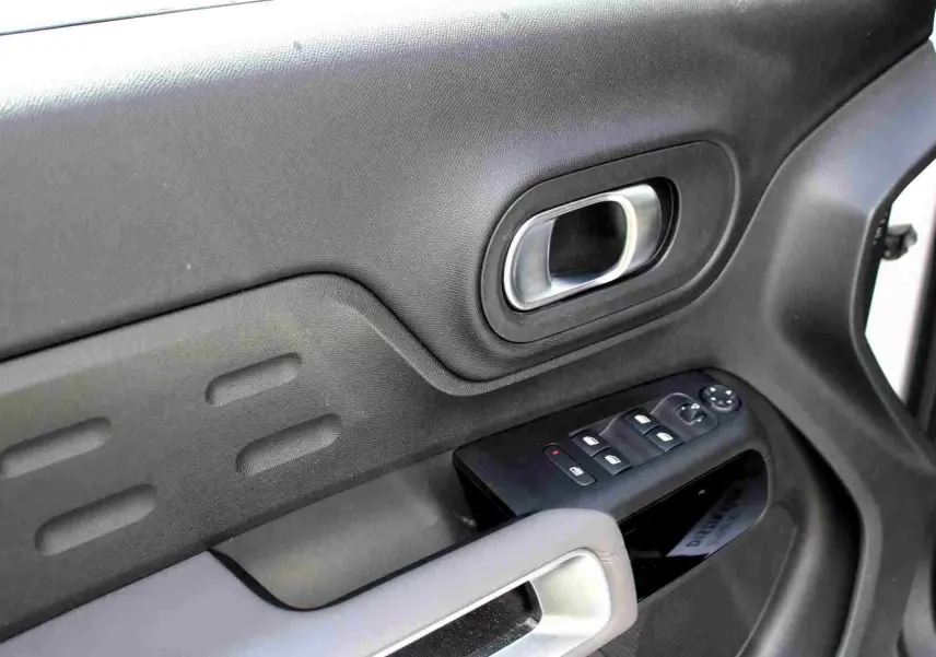 Détail de la porte intérieure côté conducteur du Citroën C5 Aircross blanc, avec commandes de vitres et poignée argentée.
