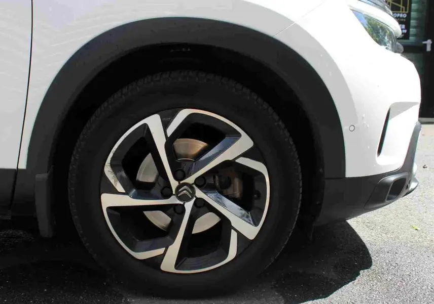 Gros plan sur la roue avant droite d'un Citroën C5 Aircross blanc 2020, mettant en valeur la jante alliage au design moderne.
