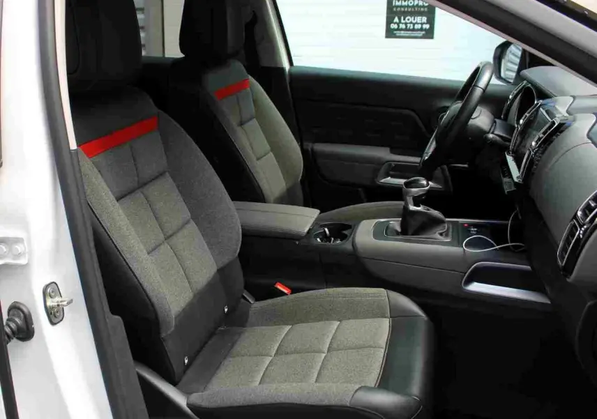 Vue intérieure côté gauche du Citroën C5 Aircross blanc 2020, sièges tissu gris avec bande rouge et console centrale noire.