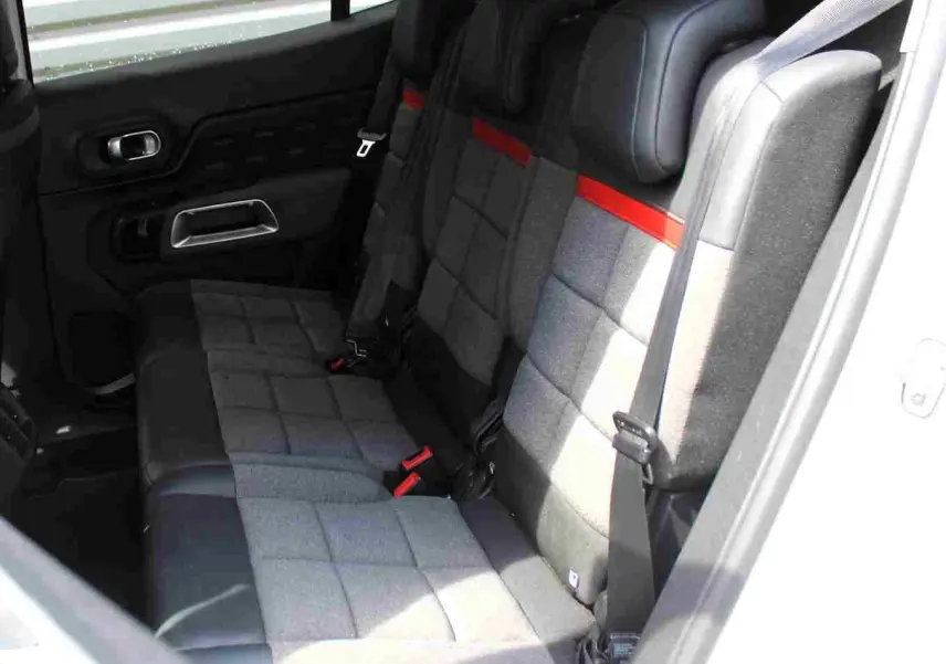 Vue intérieure côté droit montrant la banquette arrière grise avec surpiqûres rouges du Citroën C5 Aircross blanc.