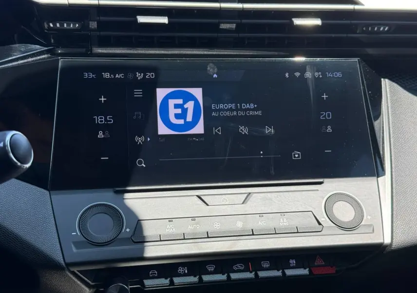 Vue rapprochée de l’écran tactile central et des commandes de climatisation d’une Peugeot 308 e-308 gris Artense.