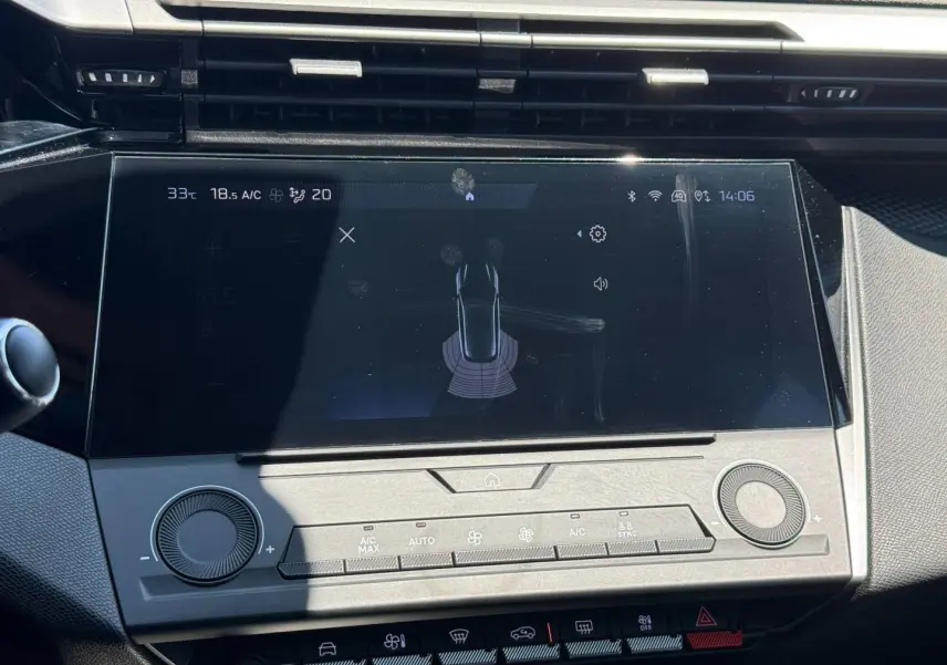 Vue rapprochée de l’écran tactile central et des commandes de climatisation du tableau de bord de la Peugeot 308 e-308 gris Artense.