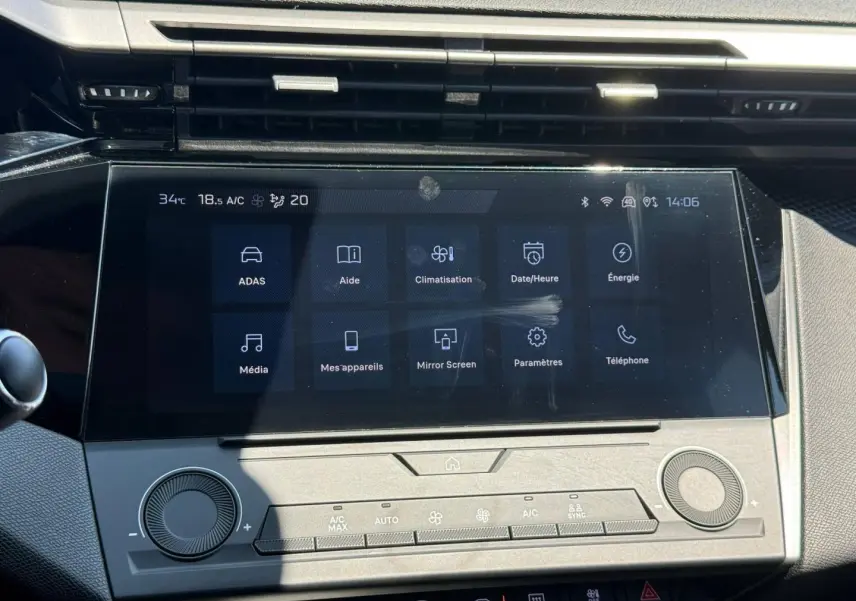 Écran tactile central et commandes climatisation de la Peugeot 308 e-308 gris Artense, vue frontale rapprochée.