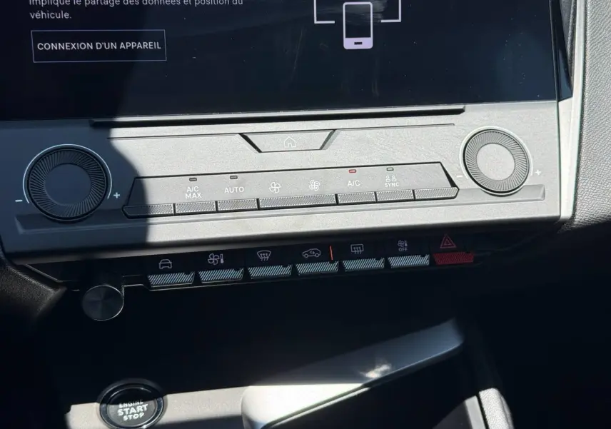 Vue rapprochée de la console centrale de la Peugeot e-308 gris Artense, avec écran tactile et commandes climatisation.