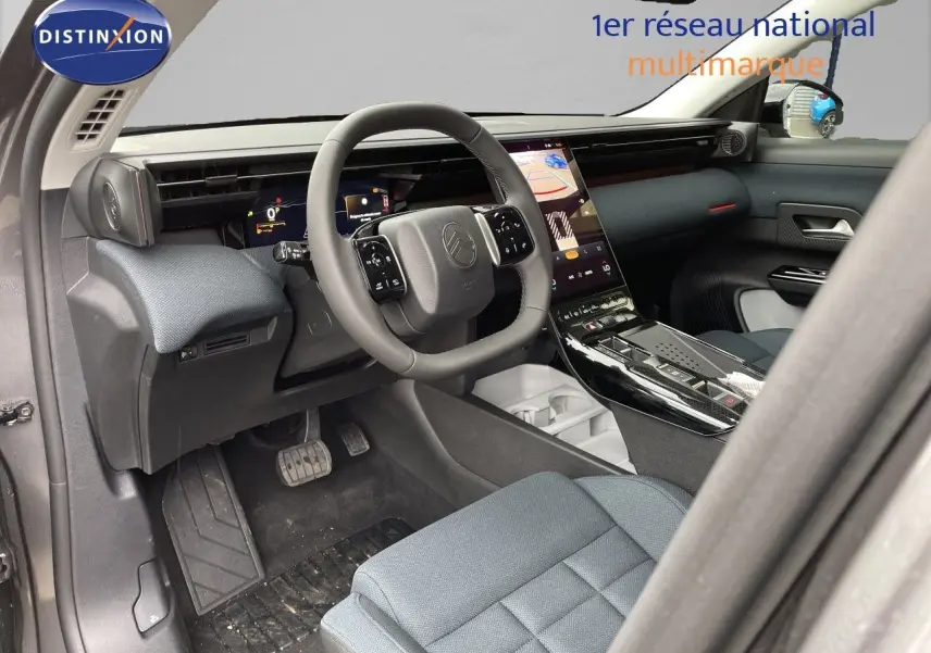 Vue intérieure côté conducteur du Citroën C5 Aircross Hybrid 2026, avec tableau de bord moderne et sellerie tissu gris.