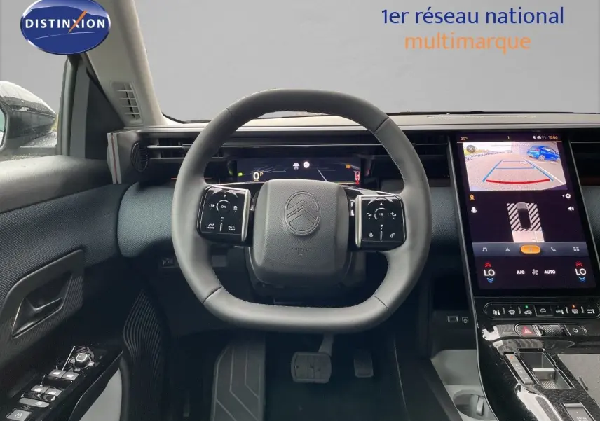 Intérieur de la Citroën C5 Aircross Hybrid 2026, vue du poste de conduite avec volant multifonction et écran tactile affichant la caméra de recul.