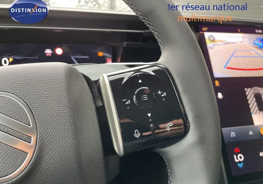 Gros plan sur la commande droite du volant noir du Citroën C5 Aircross Hybrid 2026 avec écran tactile de caméra de recul en arrière-plan.