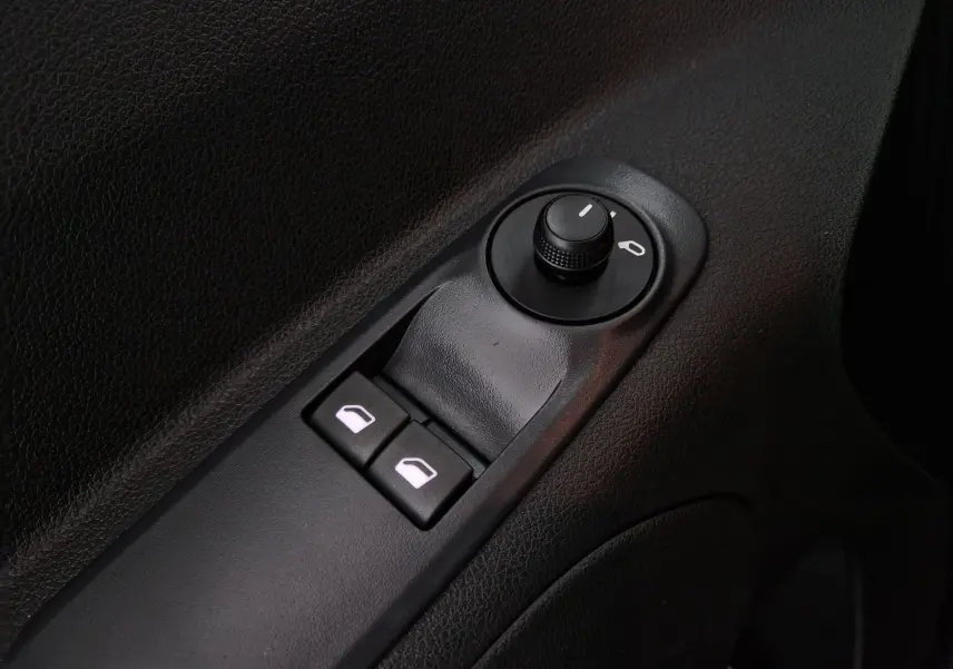 Gros plan sur les commandes de réglage des rétroviseurs et des vitres électriques côté conducteur d'un Opel Combo Life gris Artense.