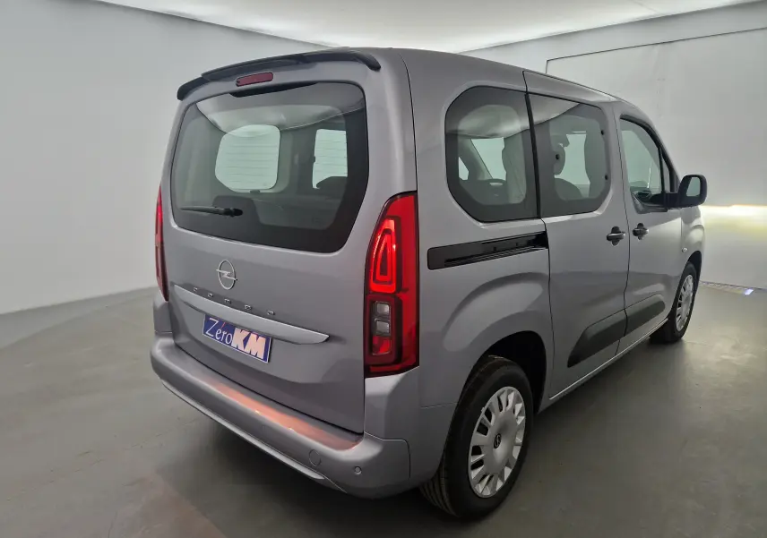 Vue 3/4 arrière droite d'un Opel Combo Life gris Artense avec vitres latérales et becquet arrière visible.