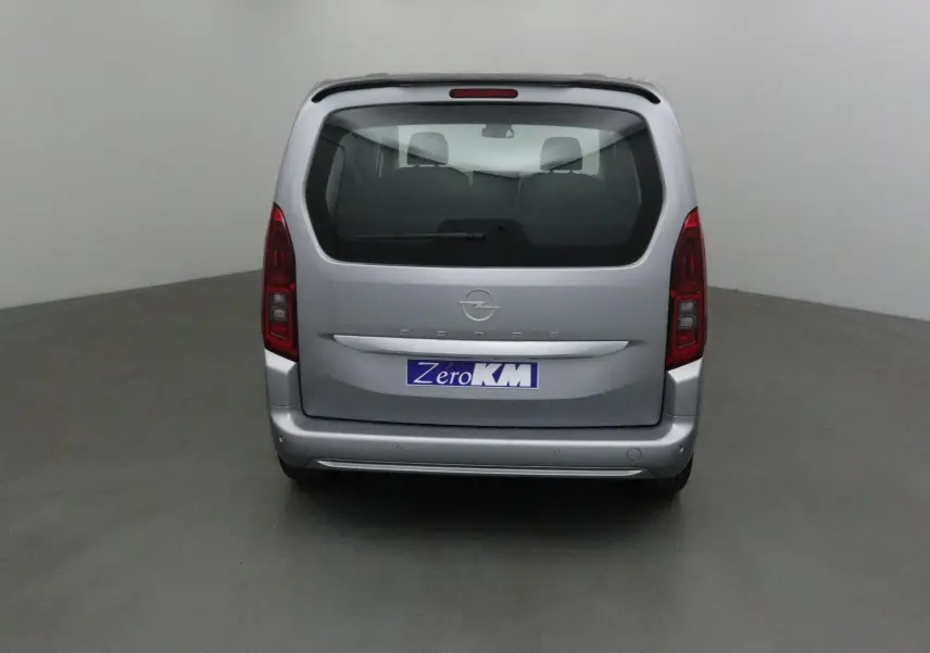 Vue arrière d'un Opel Combo Life gris Artense avec becquet et trois sièges individuels visibles à l'intérieur.
