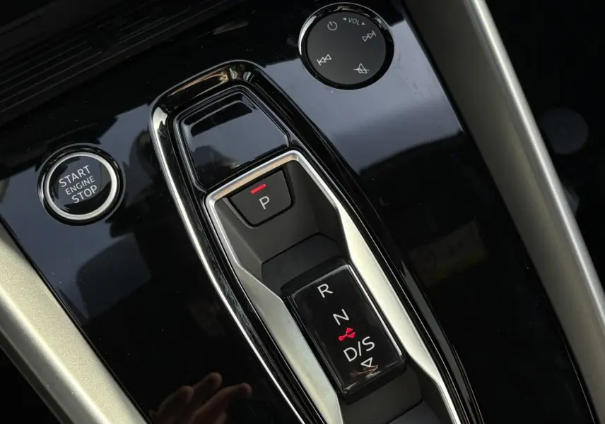 Gros plan sur la console centrale noire brillante de l'Audi A3 Berline 30 TFSI avec sélecteur de boîte auto et bouton Start/Stop.