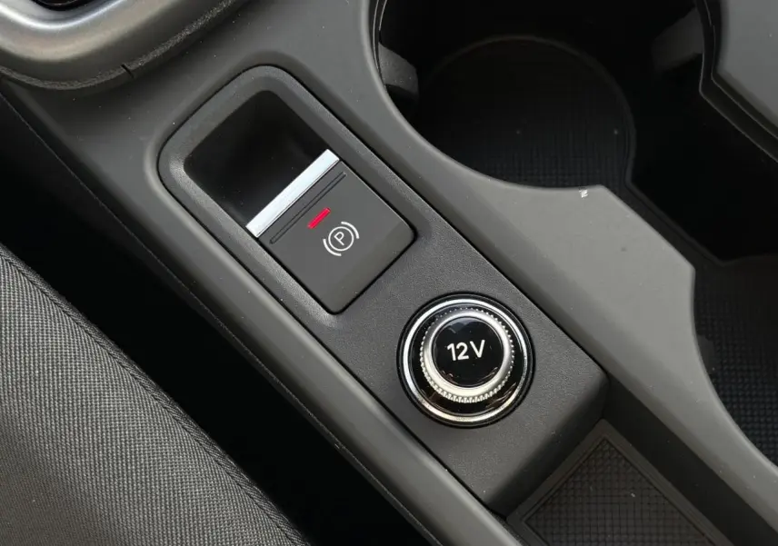 Gros plan sur la console centrale de l’Audi A3 Berline 30 TFSI noir, montrant le frein à main électronique et prise 12V.