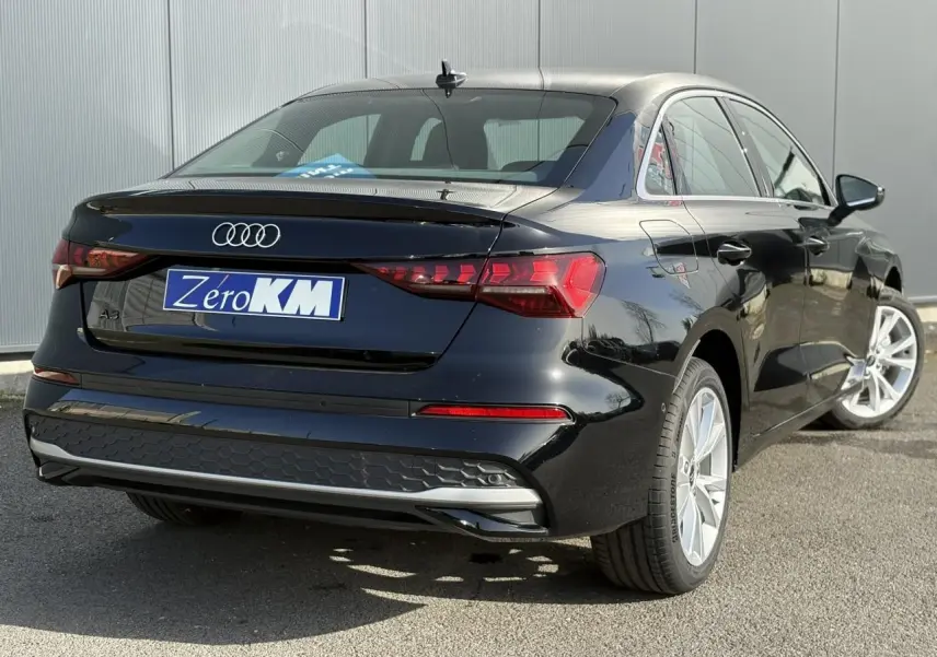 Vue 3/4 arrière droite d’une Audi A3 Berline 30 TFSI noire avec feux arrière LED et jantes alliage 17 pouces.