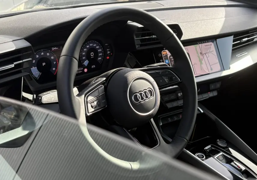 Intérieur Audi A3 Berline 30 TFSI 2024 vu côté conducteur, volant cuir multifonctions et écran tactile central.