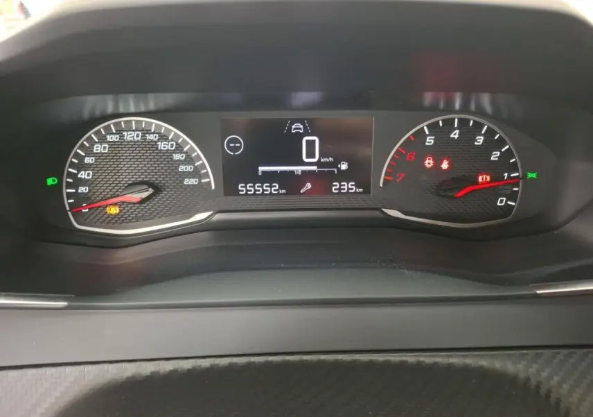 Vue rapprochée du combiné d'instruments numérique et analogique de la Peugeot 208 gris Artense, affichant 55552 km.