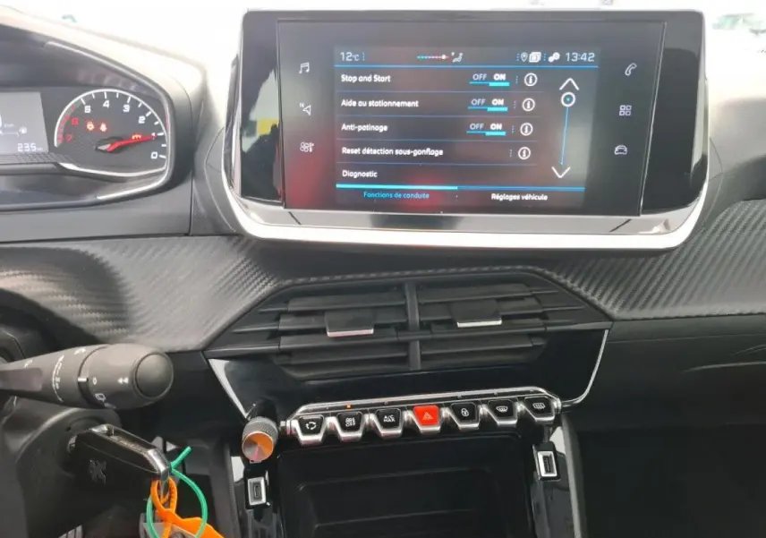 Vue rapprochée de la console centrale et du tableau de bord noir avec écran tactile et commandes sur Peugeot 208 gris Artense.