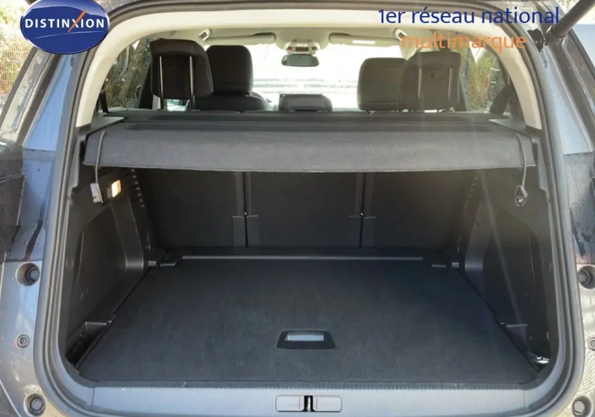 Coffre ouvert vu de l'arrière d'un Citroën C5 Aircross gris platinium métal avec cache-bagages en place.