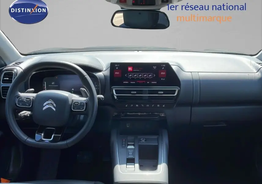 Vue intérieure du tableau de bord et volant du Citroën C5 Aircross gris platinium, avec écran tactile central et commandes au volant.