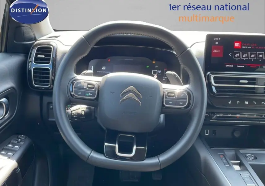 Vue intérieure centrée sur le volant cuir noir et le tableau de bord numérique du Citroën C5 Aircross gris platinium.