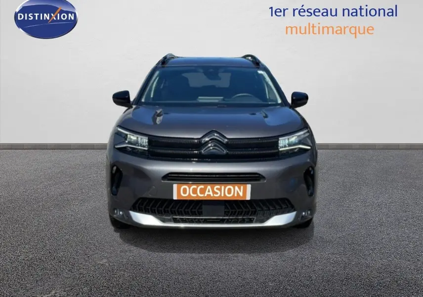 Vue avant d'un Citroën C5 Aircross gris platinium métal 2025 avec calandre noire et plaques "OCCASION" visibles.