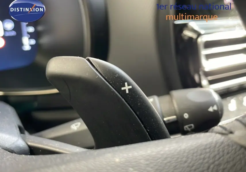 Gros plan sur la palette de changement de vitesse "+" côté droit du volant dans l'habitacle d'un Citroën C5 Aircross gris platinium.