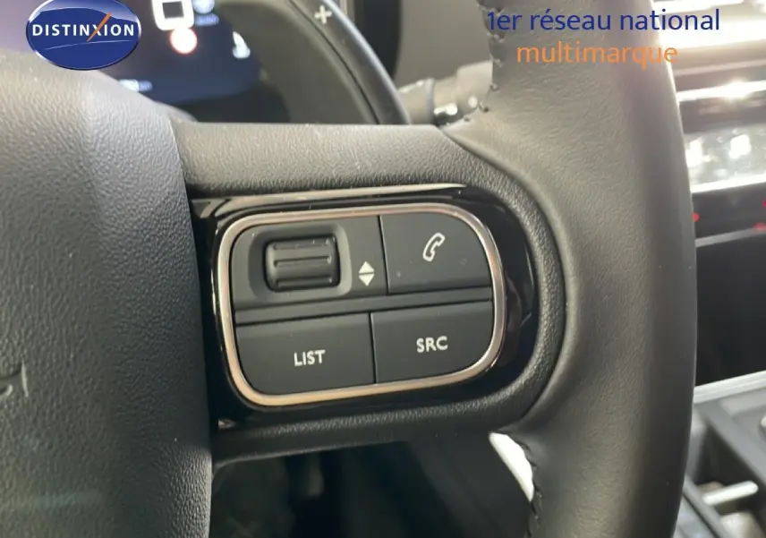 Gros plan sur les commandes gauche du volant cuir du Citroën C5 Aircross gris platinium, avec boutons de téléphonie et audio.