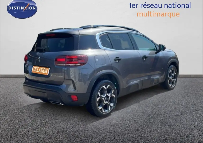 Vue 3/4 arrière droite d’un Citroën C5 Aircross gris platinium métal avec jantes bi-ton et toit ouvrant.
