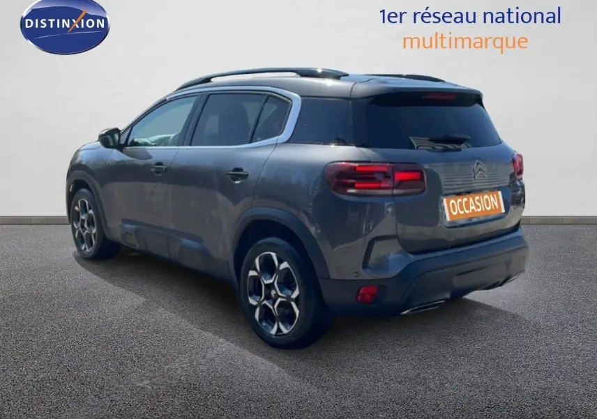 Vue 3/4 arrière droite d’un Citroën C5 Aircross gris platinium métal avec jantes bi-ton et toit panoramique.