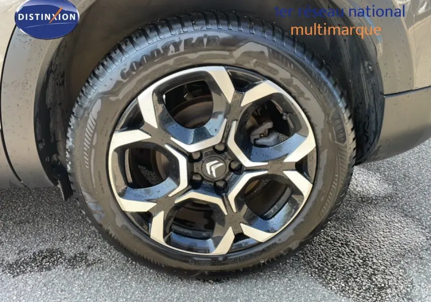 Gros plan sur la roue avant droite du Citroën C5 Aircross gris platinium métal avec jante alliage bicolore.