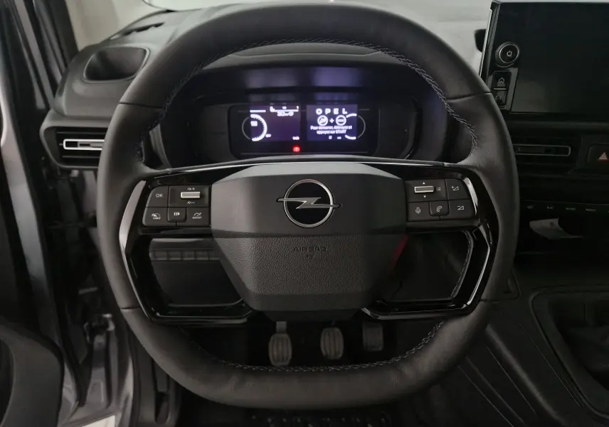 Vue frontale du volant en cuir noir de l'Opel Combo Life gris Artense avec commandes intégrées et tableau de bord numérique.