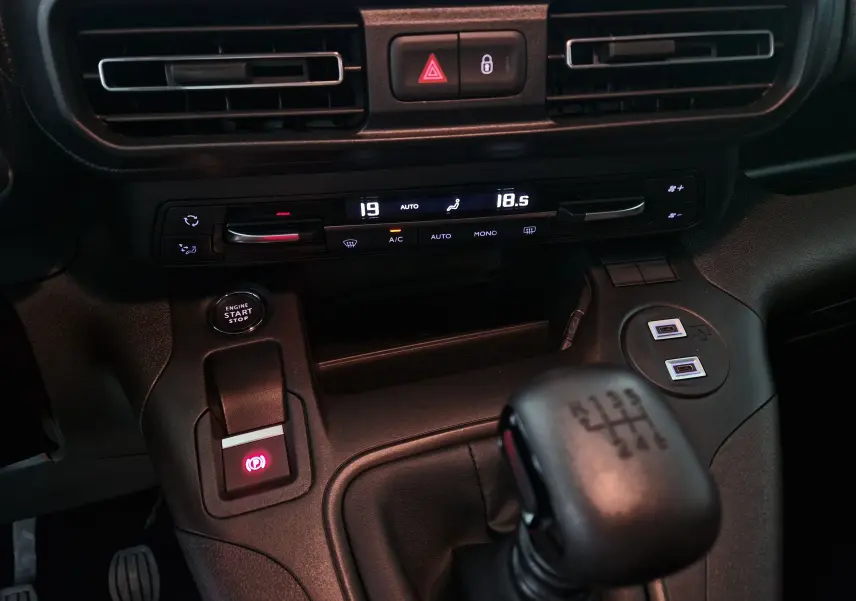 Vue rapprochée de la console centrale de l'Opel Combo Life gris Artense, avec boîte manuelle et commandes climatisation digitale.