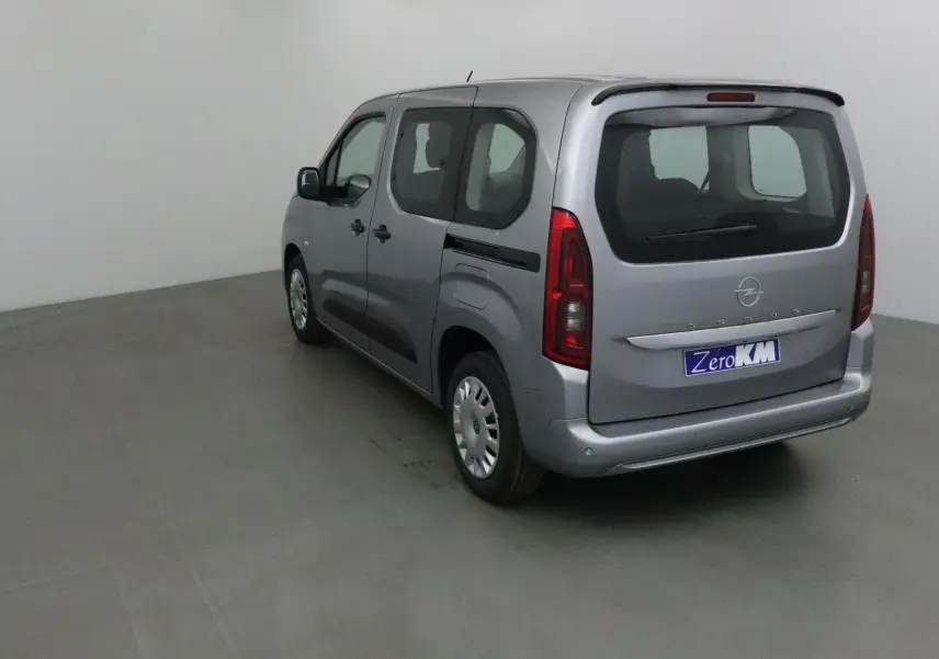 Vue 3/4 arrière droite d'un Opel Combo Life gris Artense avec becquet et vitres teintées en intérieur neutre.