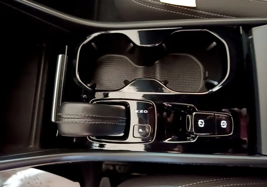 Vue rapprochée de la console centrale noire du Volvo XC40 T2 2020, avec levier de vitesses et porte-gobelets.