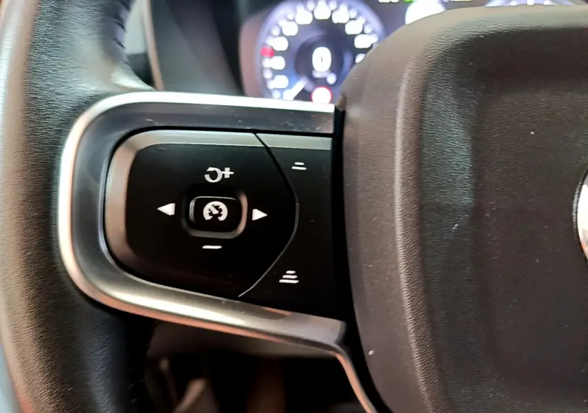 Gros plan sur les commandes de régulateur de vitesse au volant cuir noir du Volvo XC40 T2 Momentum 2020.