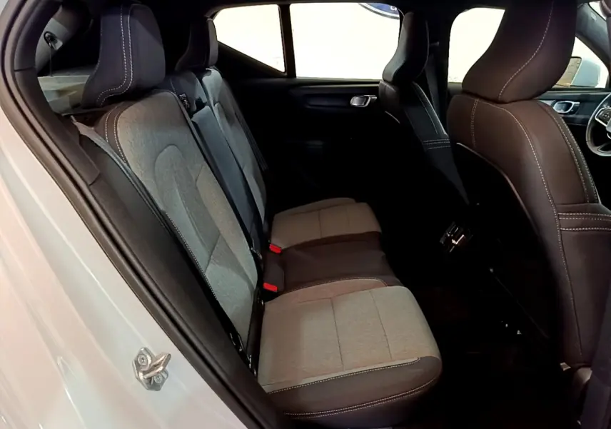 Vue côté gauche de l'habitacle arrière du Volvo XC40 T2 gris clair, montrant les sièges bicolores tissu et cuir.