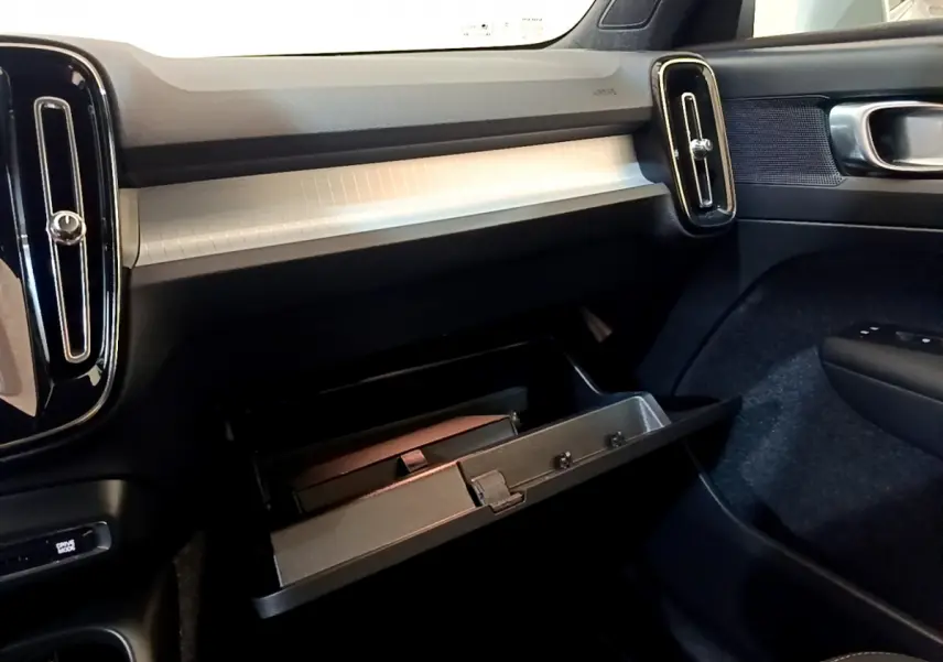 Intérieur du Volvo XC40 T2 2020, vue côté passager sur la boîte à gants ouverte et la planche de bord grise.